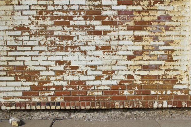 istock Grungy antique brick wall background with significant staining and peeling white paint 1215272018