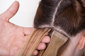 Natural Hair extensions at salon, close-up hands in hair