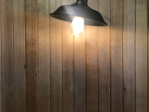 istock Tungsten bulb  Shining light on the wooden wall 1215275781