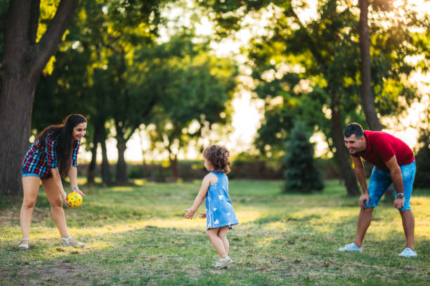 istock Parents playing with daughter in park 1215278467