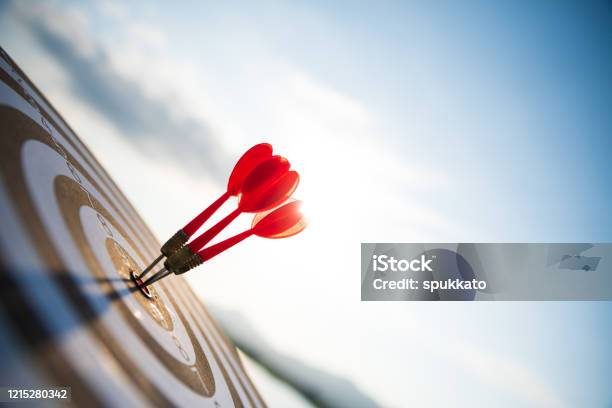 Close Up Shot Red Darts Arrows In The Target Center On Dark Blue Sky Background Business Target Or Goal Success And Winner Concept Stock Photo - Download Image Now
