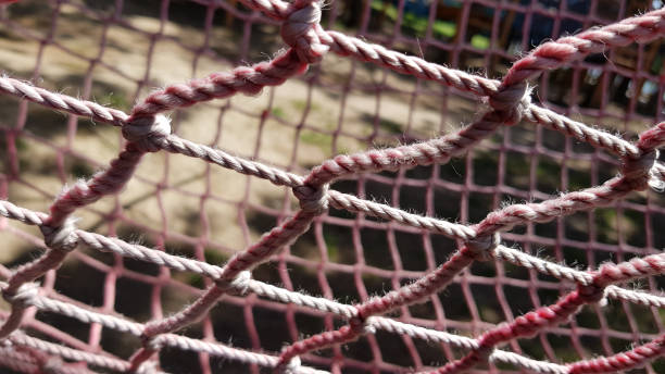 istock Yarn mesh texture. Closeup of old twisted pink net on blurry background. Rhombus pattern of soccer gate net. Rope texture with tied knots. 1215281826