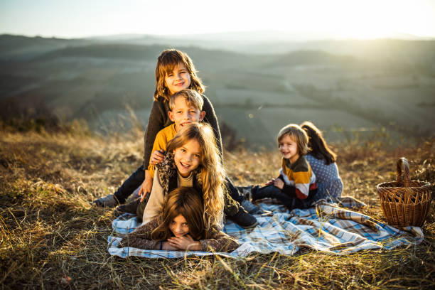 istock Happy kids making human pyramid on picnic in autumn day. 1215283543