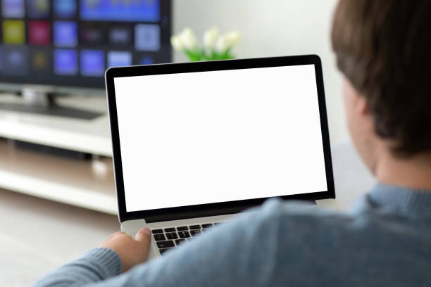 istock man holding laptop with isolated screen in the room 1215290721