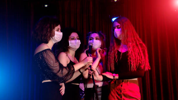 保護フェイスマスク付きナイトクラブでカラオケをしている友人のグループ - turkish culture audio ストックフォトと画像