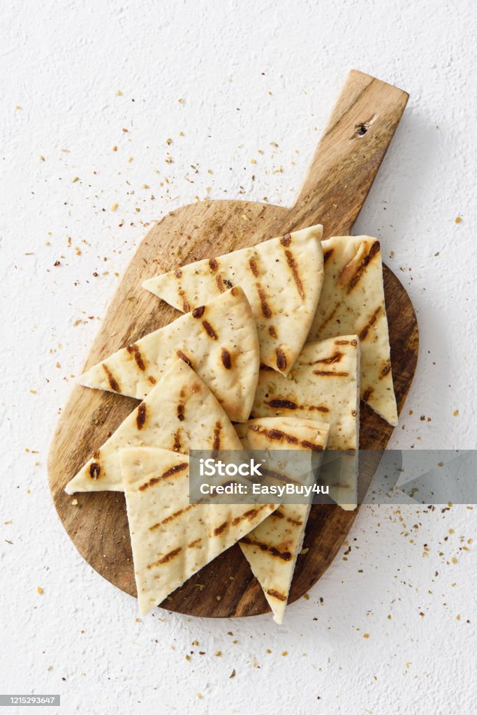 Grilled pita bread Grilled greek pita bread chips with seasoning on a wooden cutting board Pita Bread Stock Photo