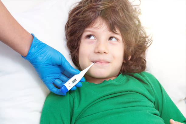 istock Child thermometer,Doctor checking on sick little boys temperature 1215294158