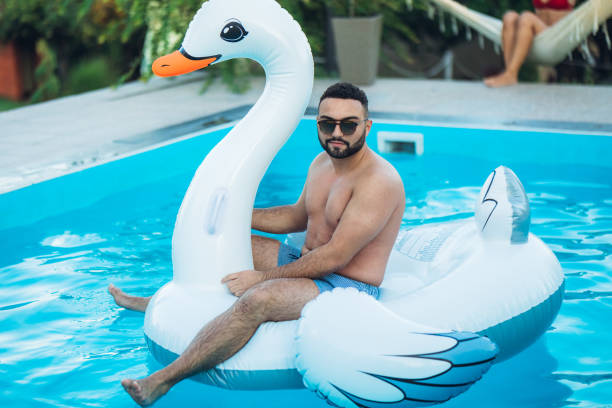 istock Carefree man on float swan 1215295003
