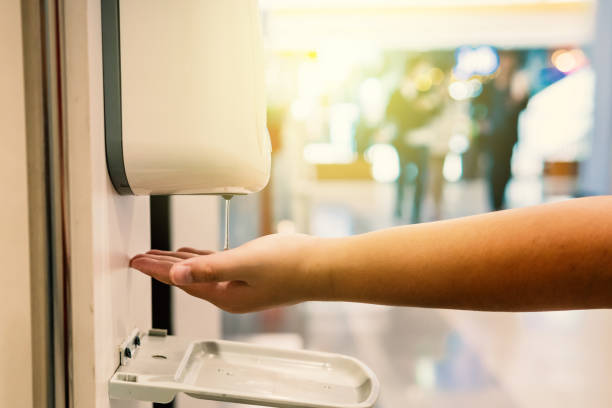 the boy is taking alcohol gel from the automatic drip machine in the mall. - hand sanitizer liquid soap hygiene healthy lifestyle imagens e fotografias de stock