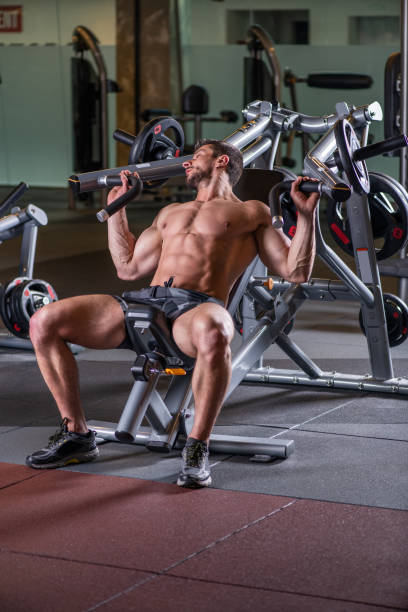 istock Sexy young muscular man doing upper chest exercise on the machine 1215298357