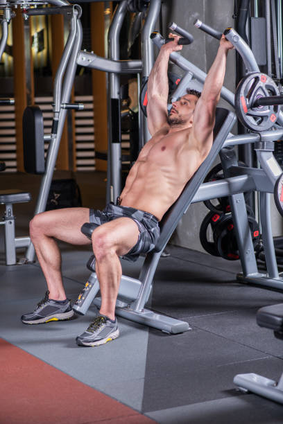 istock Sexy young muscular man doing upper chest exercise on the machine 1215298365