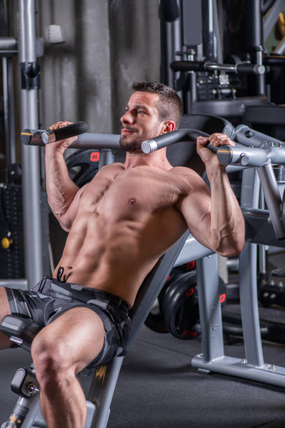 istock Sexy young muscular man doing upper chest exercise on the machine 1215298367