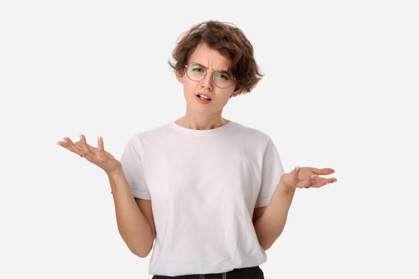 clueless young woman in a white shirt and eyeglasses shrugging shoulders being at loss. - blank expression head and shoulders horizontal studio shot imagens e fotografias de stock