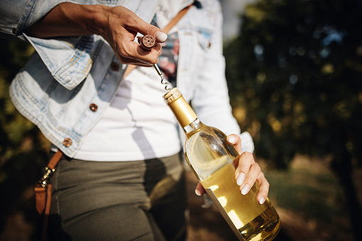 Wine bottle is opened with corkscrew.