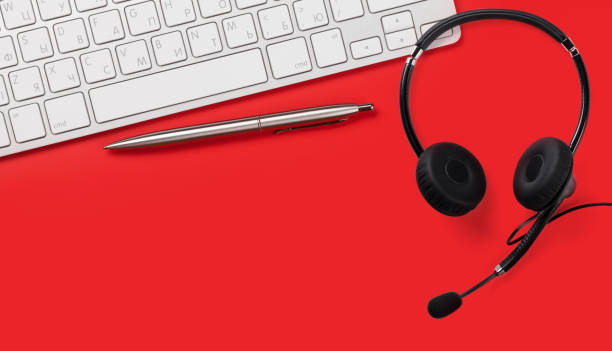 istock Office red desk with supplies and headset 1215299156