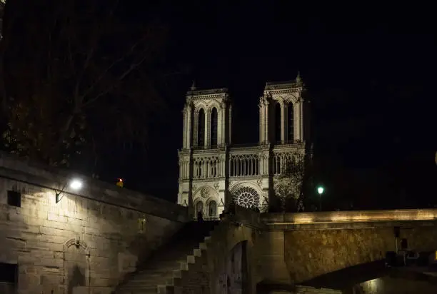 Photo of Notre Dame de Paris cathedral at night .