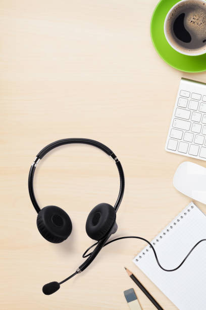 istock Office wooden backdrop with supplies and headset 1215299379