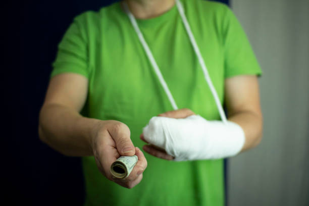 um homem com um braço engessado contou dinheiro do custo e despesas do atendimento médico de emergência no hospital. - unfortunately - fotografias e filmes do acervo