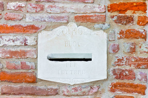 istock Old italian stone postal mailbox against a brick wall 1215302976