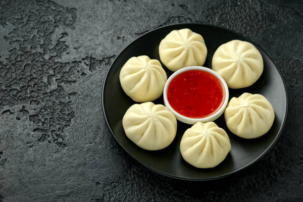 istock Steamed Buns with duck stuffing, chili sauce on black plate 1215304663