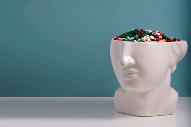 The head of a statue with a pill brain. Concept: Mind and medicine. Blue background, space for text stock photo