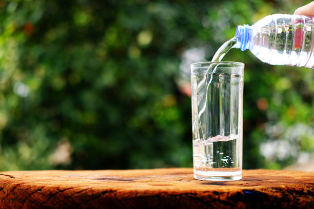 istock Drinking water on wooden table background 1215305665