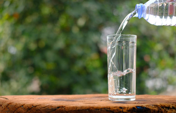istock Pouring drinking water on wooden table background 1215305717