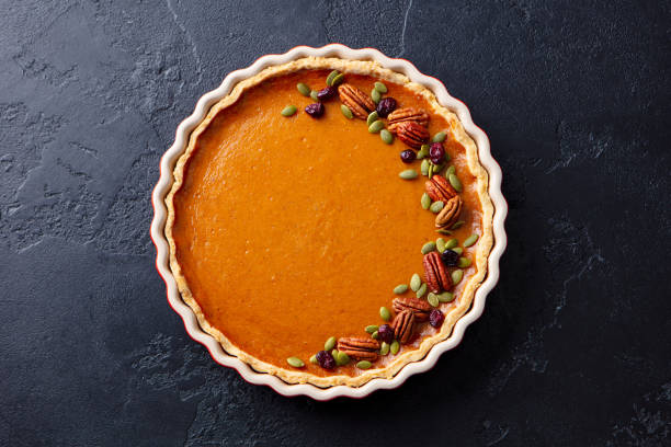 istock Pumpkin pie in baking dish. Dark background. Close up. Top view. 1215305815