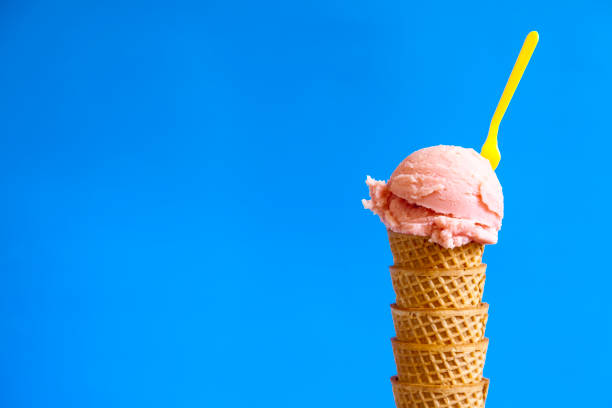 istock strawberry ice cream ball and yellow plastic teaspoon 1215307276