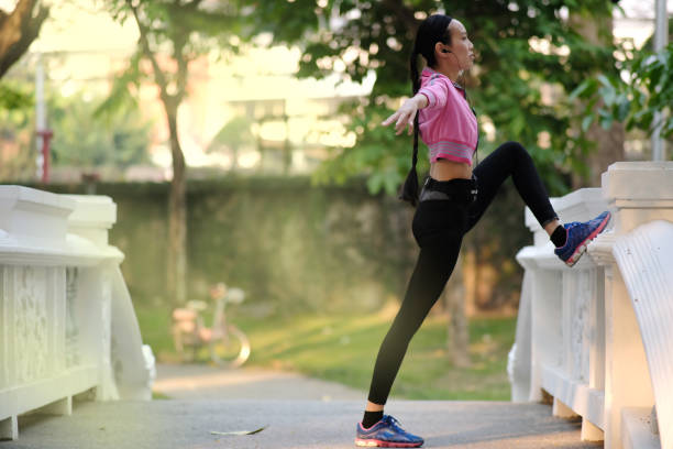 istock Young woman doing exercises in the park 1215308057