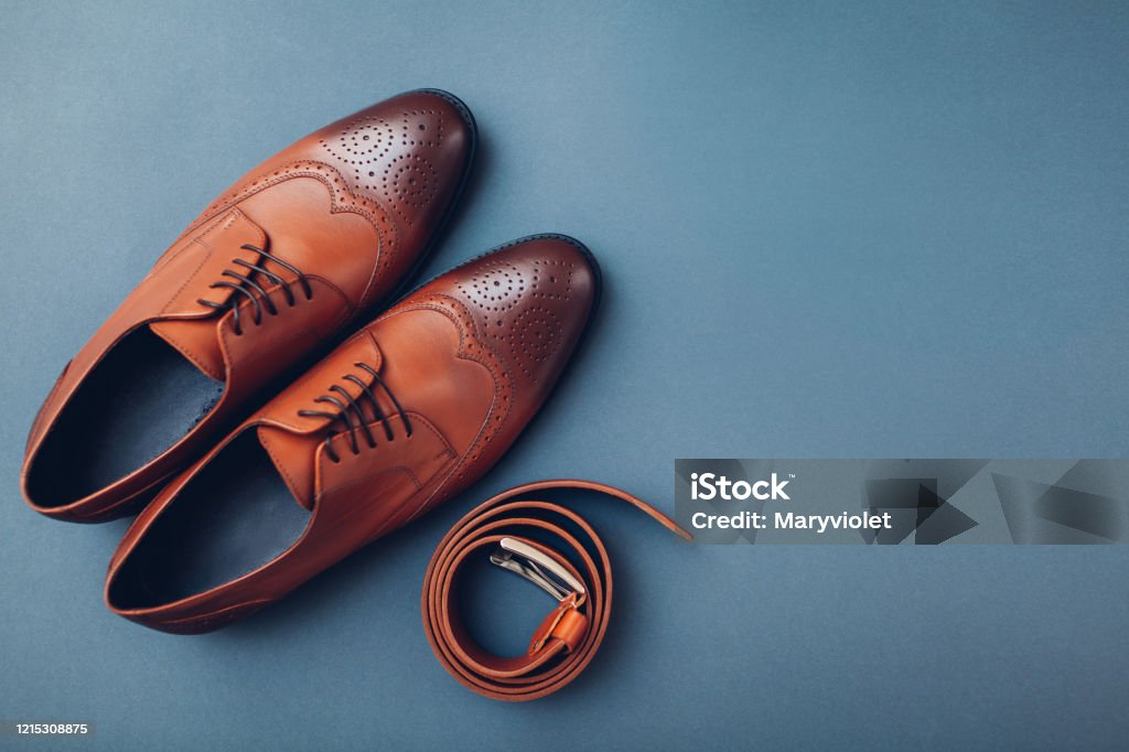 Oxford male brogues shoes with accessories. Men's fashion. Classical brown leather footwear with belt. Space Oxford male brogues shoes with accessories. Men's fashion. Classical brown leather footwear with belt. Top view. Space Shoe Stock Photo