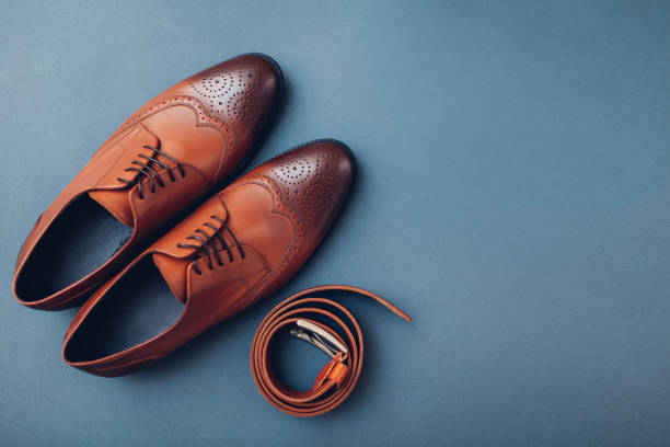 Oxford male brogues shoes with accessories. Men's fashion. Classical brown leather footwear with belt. Space Oxford male brogues shoes with accessories. Men's fashion. Classical brown leather footwear with belt. Top view. Space brogue photos stock pictures, royalty-free photos & images