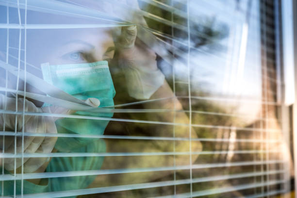 trabajador de atención médica preocupado mirando a través de una ventana - isolated despair hope assistance fotografías e imágenes de stock