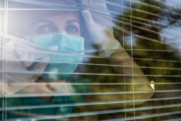besorgter mitarbeiter im gesundheitswesen schaut durch ein fenster - behind glass concept hope stock-fotos und bilder