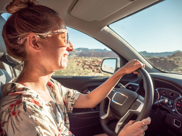 istock Cheerful young woman driving car 1215312586