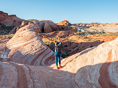 Hiker woman on top of red sandstone arms outstretched