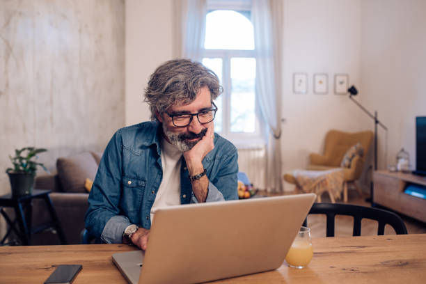istock Mature man freelancing from home during the COVID-19 lockdown 1215312769