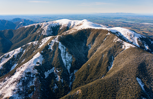 Sunrise on the rocky summit of Esk Pike in the Lake District with mist and snow.