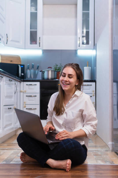 istock Girl in kitchen with laptop 1215317121