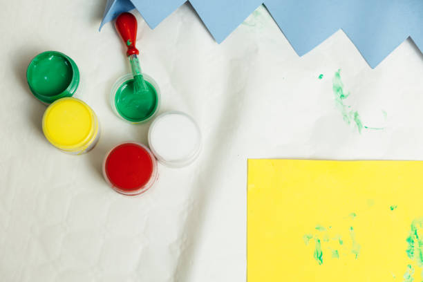 istock paints and paintbrush on a table next to cardboard to do a children's activity 1215318915