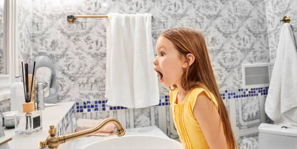 little kid girl making shocked face while she looking at mirror - surprise child little girls shock imagens e fotografias de stock