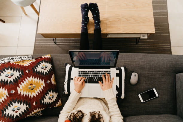 istock Young woman working from home sitting on the sofa 1215319701