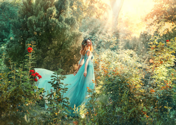 fairytale nymph enjoy bright sun in green forest. hairstyle decorated blue flowers flowing hair. fairy in long blue airy dress train fly wavy. backdrop natural tree bushes of red roses divine sunbeams - paintings landscape fairy tale painted image imagens e fotografias de stock