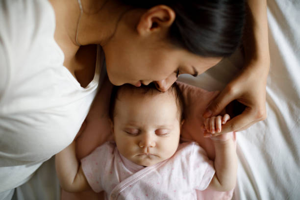 istock Mother and baby sleeping together at home 1215319963