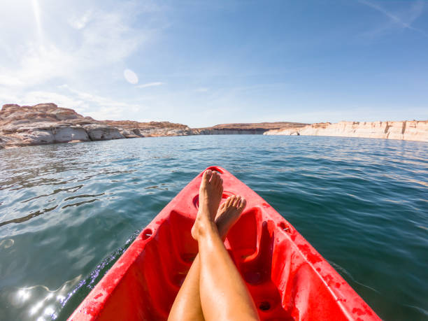 Personal perspective of young woman relaxing on red canoe floating on lake Point of View of a young woman paddling on red canoe, Arizona, USA page arizona stock pictures, royalty-free photos & images