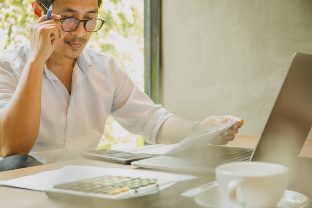istock Businessman reading paperwork documents with business reports in office. 1215320209