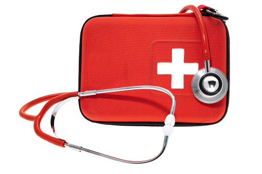 Red first aid kit with a stethoscope - white background