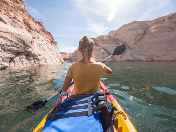 istock Rear view of young woman canoeing inside canyon 1215320471