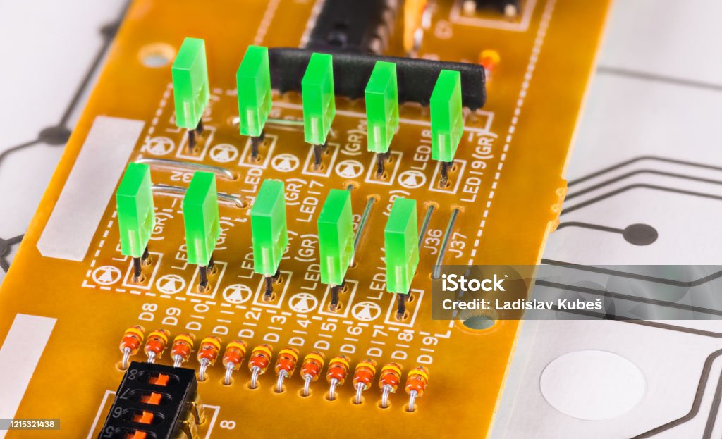 Green rectangular light-emitting diodes in rows on a beige printed circuit board Electronic components - diode. Plastic LED lights, switch, resistor or microchip. Flexible membrane on flex PCB of dismantled keybord. Electrotechnology, electrotechnics. Waste sorting and disposal Hole Stock Photo