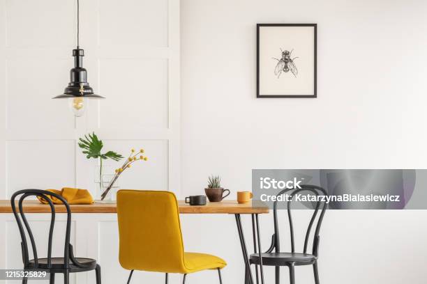 Stylish Yellow Chair At Wooden Dining Table In Trendy Interior Stock Photo - Download Image Now